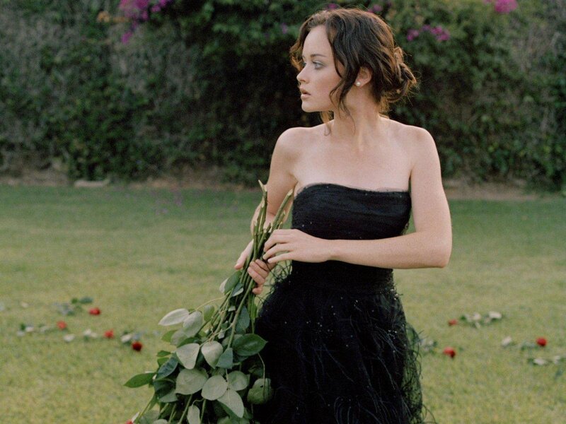 Woman in black dress holding flowers