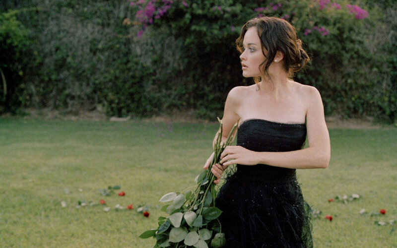 woman in black dress holding flowers