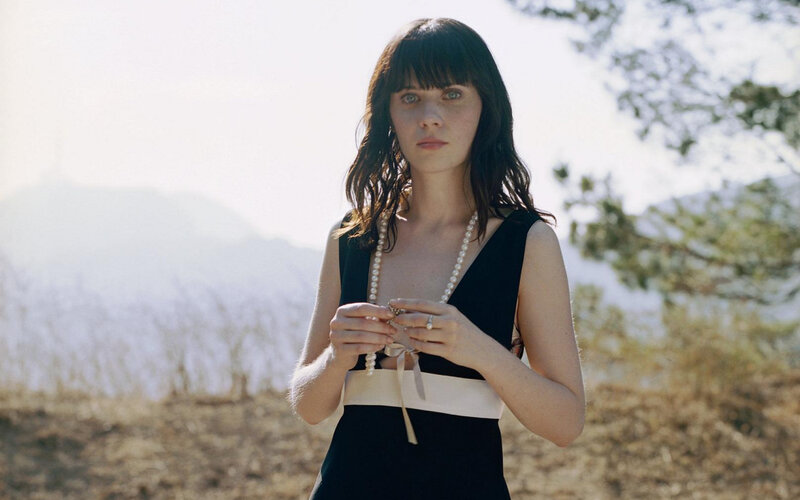 woman in black dress holding pearls