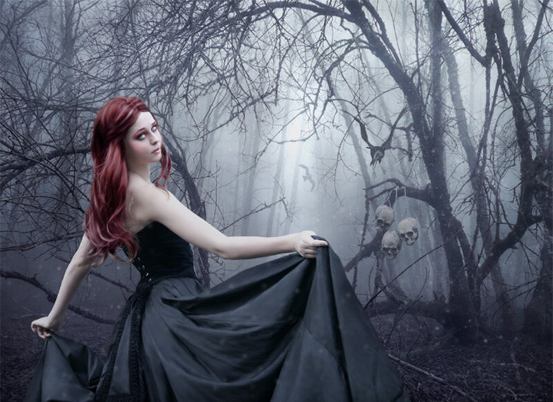 Woman in black dress in a spooky forest