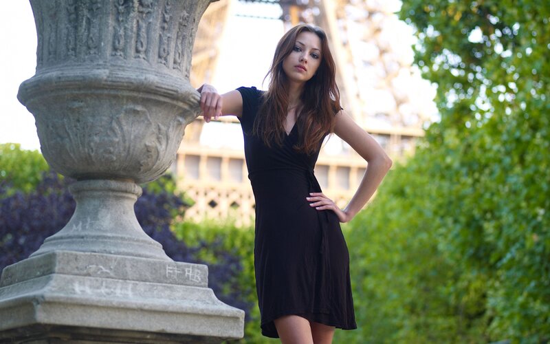 Woman in black dress near Eiffel Tower