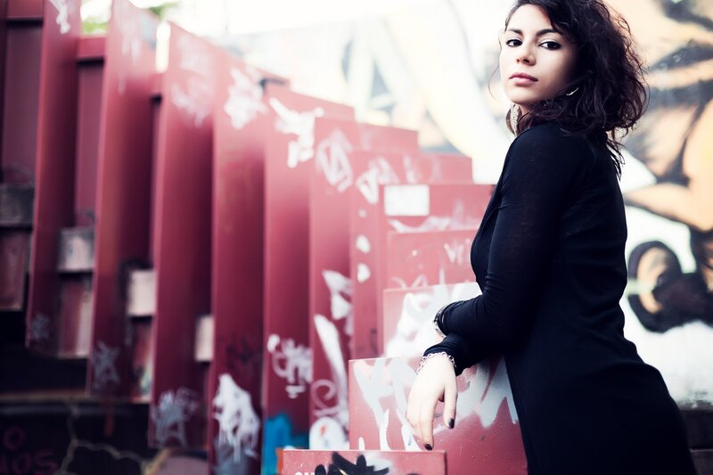 woman in black dress near graffiti