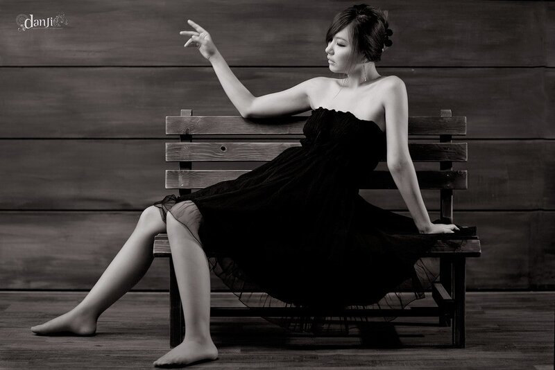 woman in black dress on bench