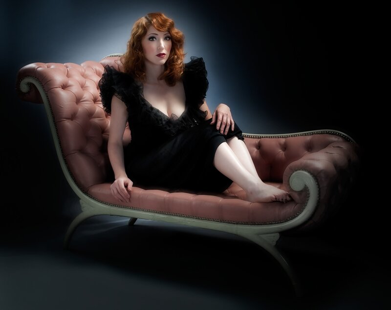 Woman in black dress on chaise lounge