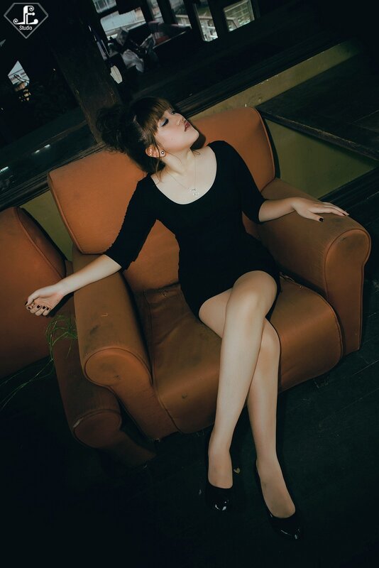 Woman in black dress on couch
