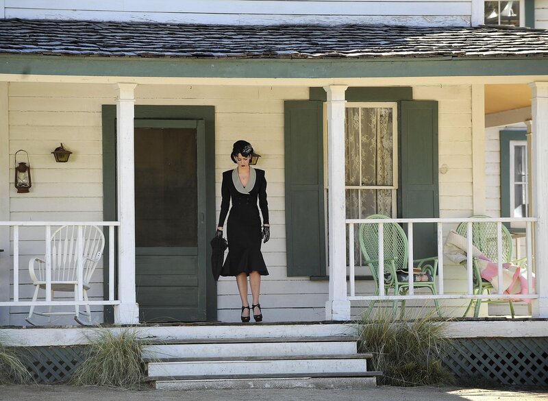 Woman in black dress on porch