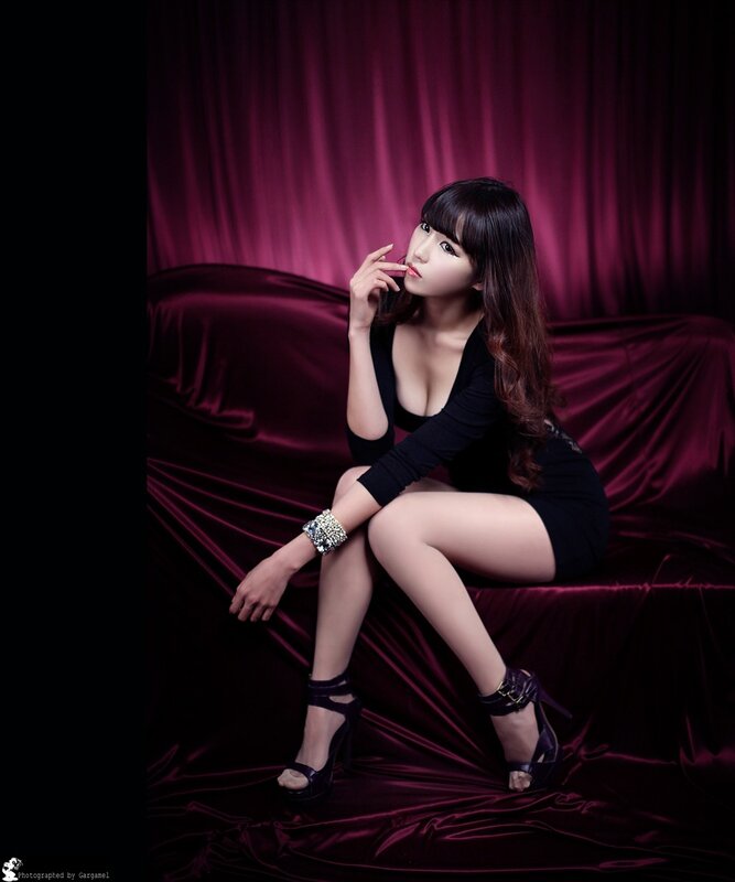 woman in black dress on red couch
