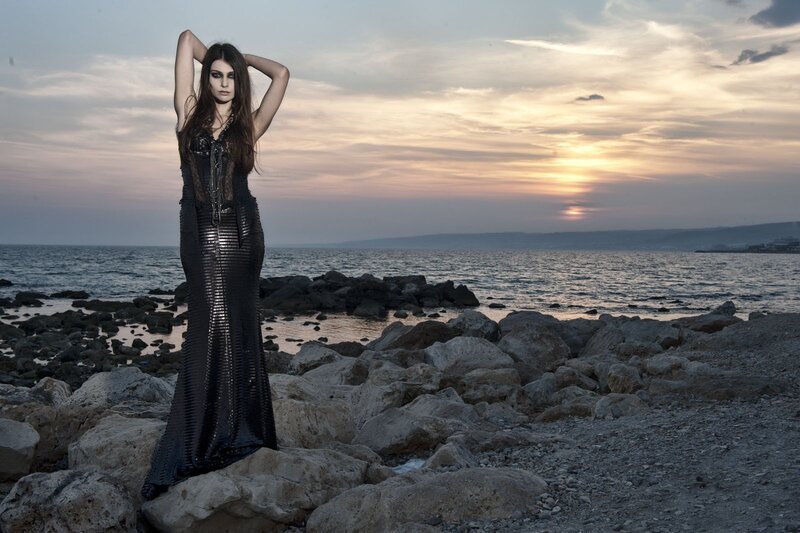Woman in black dress on rocky shore
