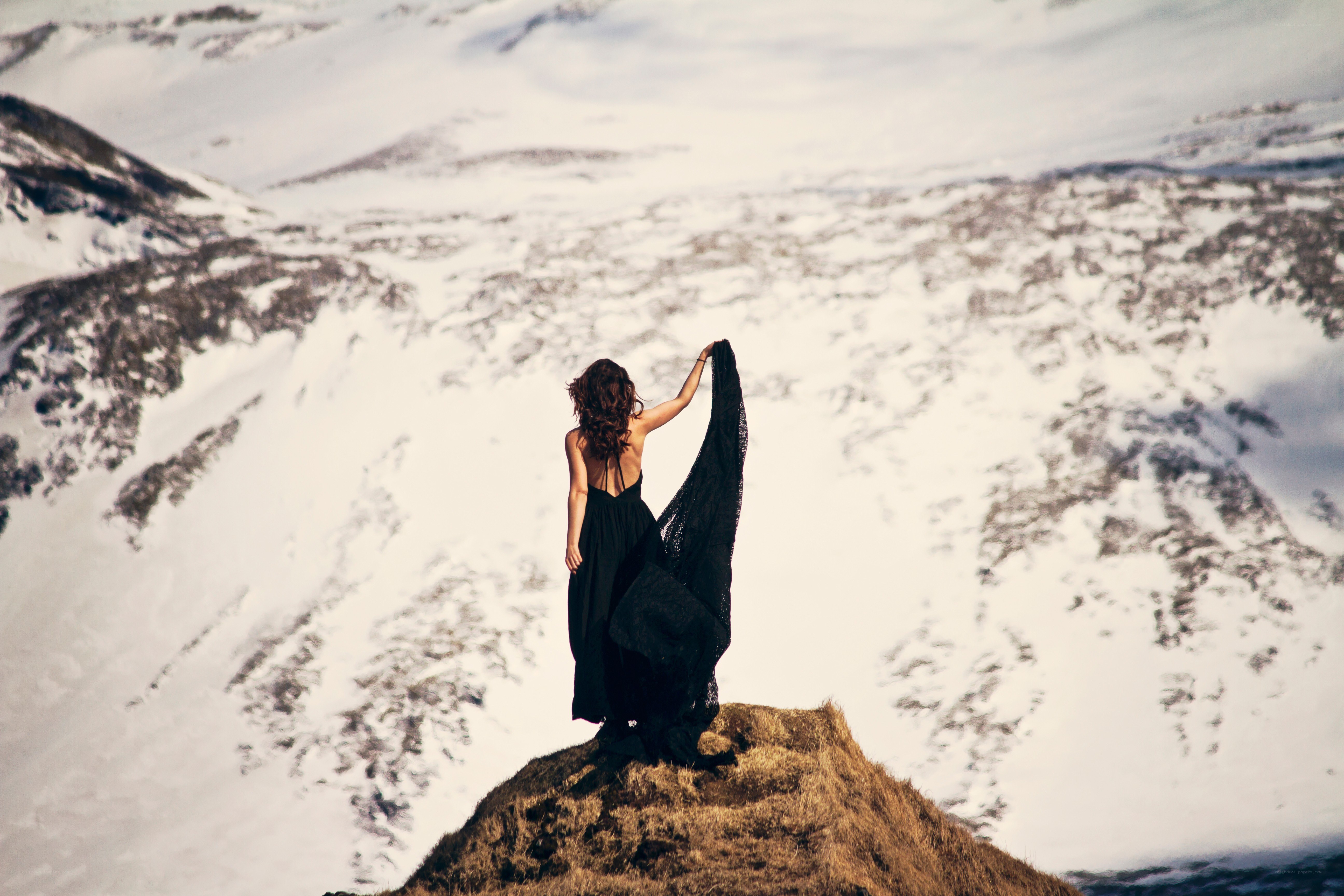 Woman in black dress on snowy mountain