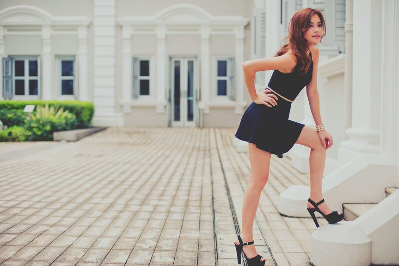 woman in black dress posing outside
