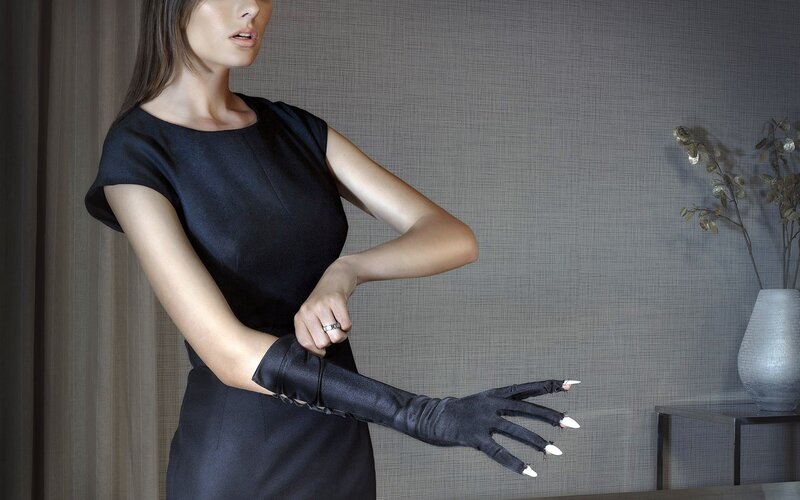 woman in black dress putting on gloves