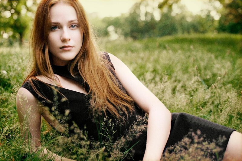 woman in black dress sitting in field