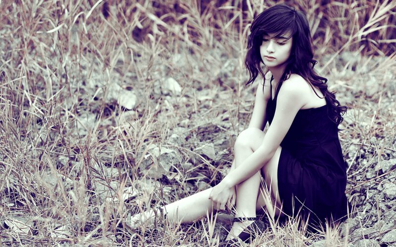 woman in black dress sitting in grass