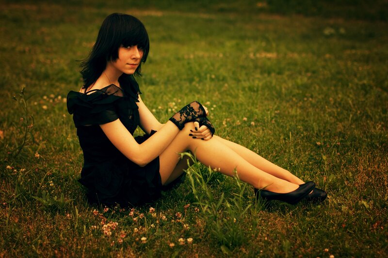 woman in black dress sitting on grass