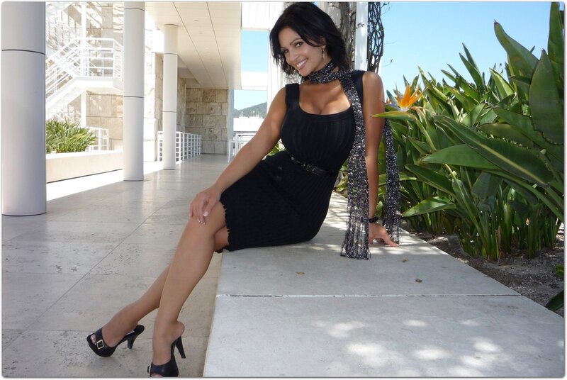 Woman in black dress sitting outside