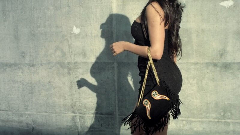 woman in black dress with fringed bag