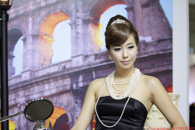 Woman in black dress with pearls