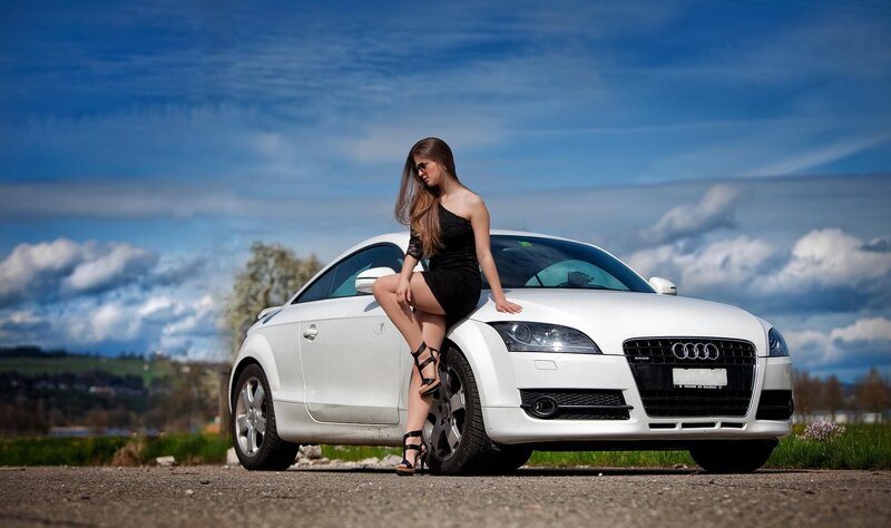 woman in black dress with white car