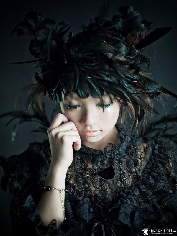 woman in black feathered attire