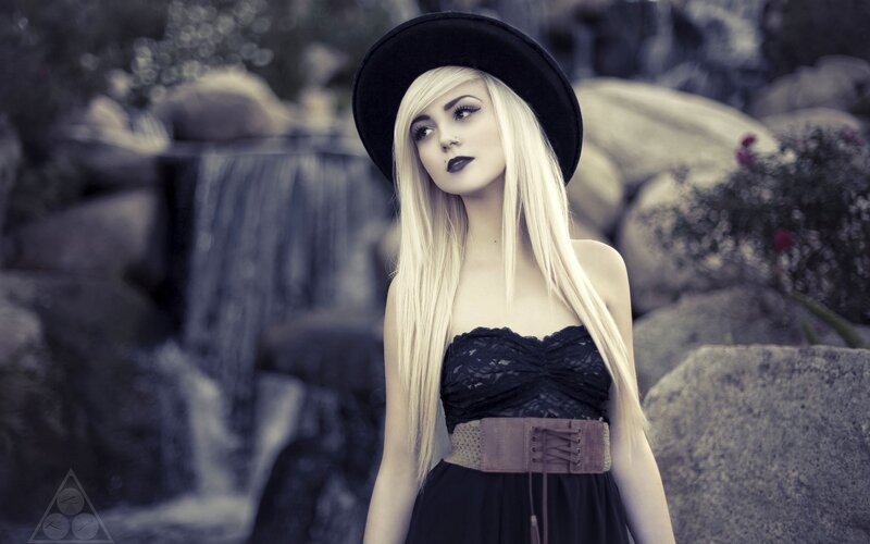 woman in black hat by waterfall