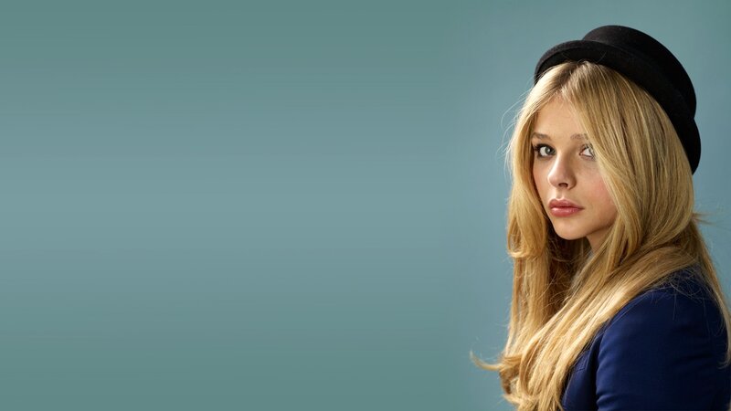 woman in black hat looking at camera