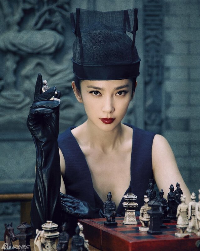 woman in black hat with chess pieces