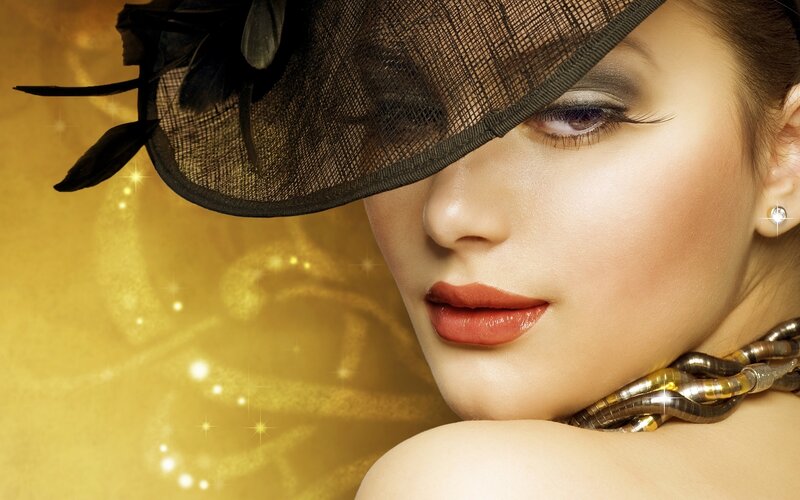 woman in black hat with golden background