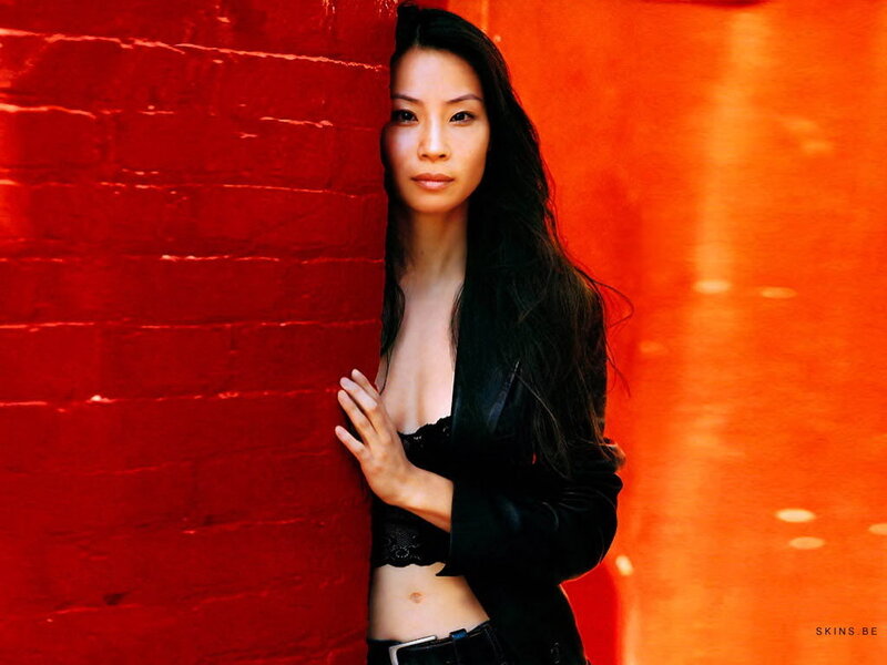 woman in black jacket against red wall