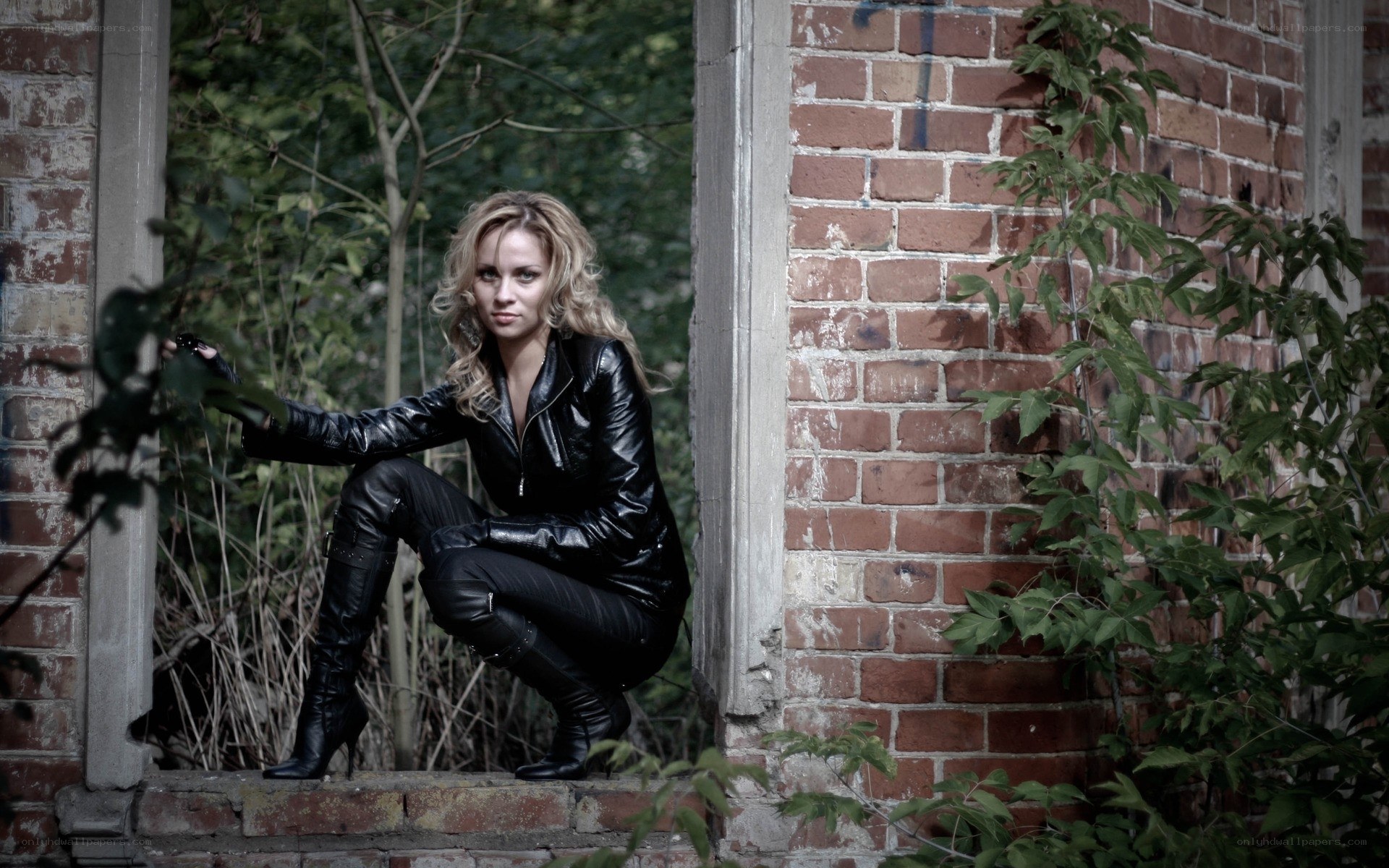 woman in black leather crouching
