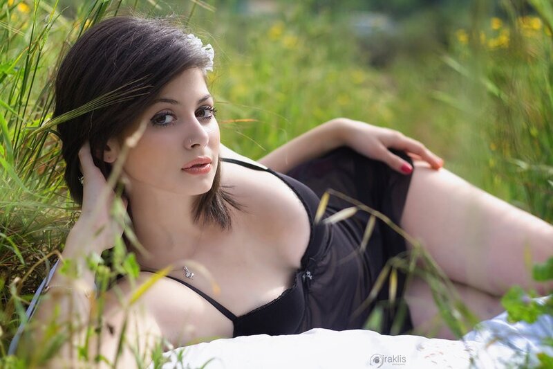 Woman in black lingerie lying in grass