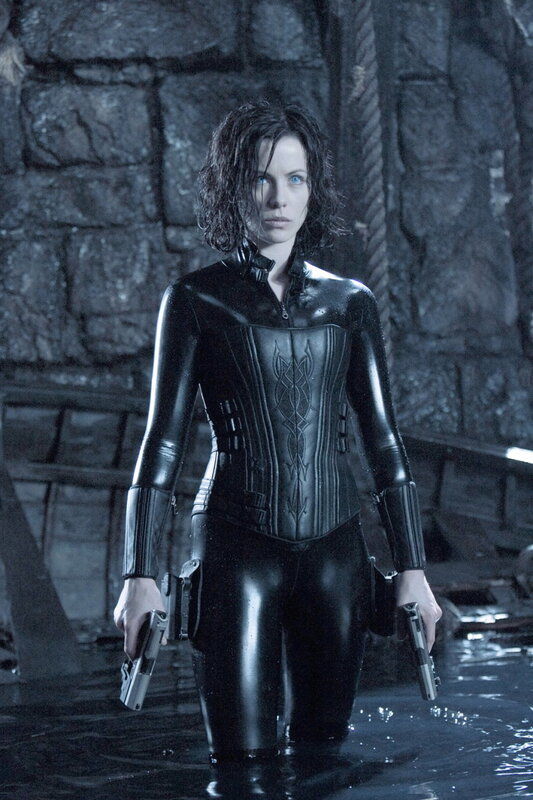woman in black suit holding guns