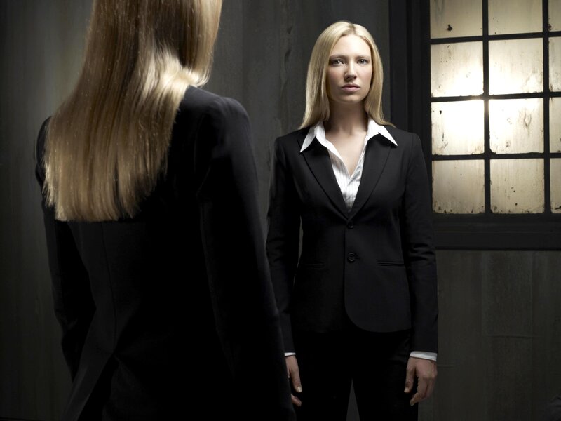 woman in black suit looking at mirror