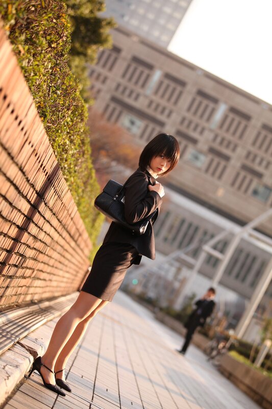 woman in black suit on sidewalk
