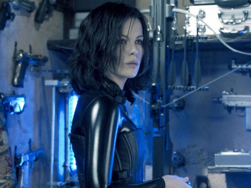 Woman in black suit with weapons