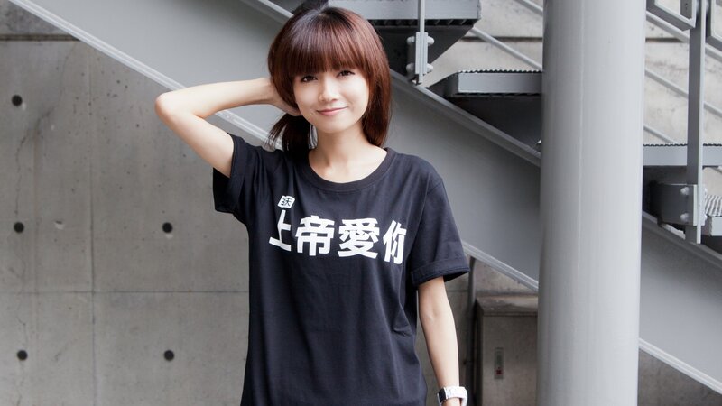 Woman in Black T-shirt — Neutral, Photograph, Concrete Wall