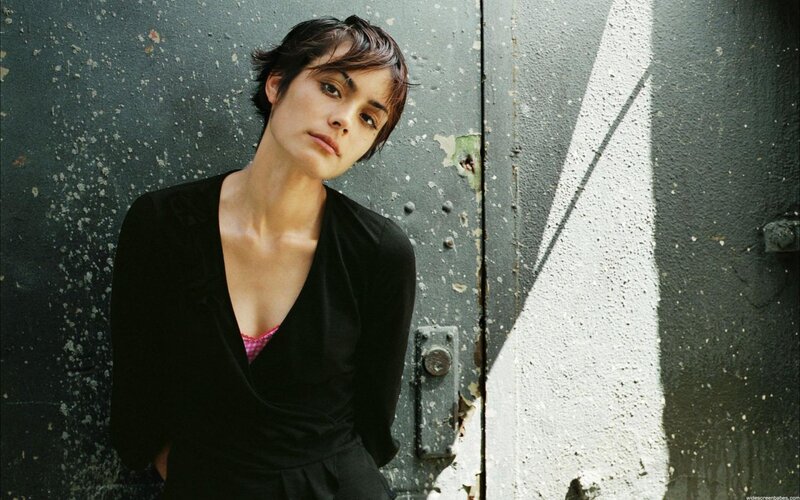 woman in black top against wall
