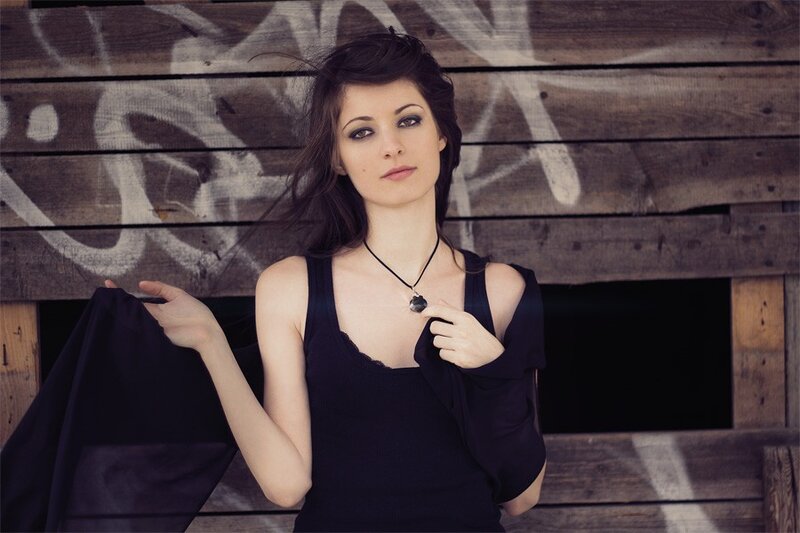 woman in black top against wooden wall