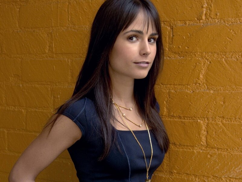 woman in black top against yellow wall
