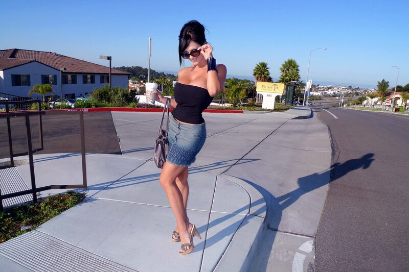 Woman in black top and denim skirt