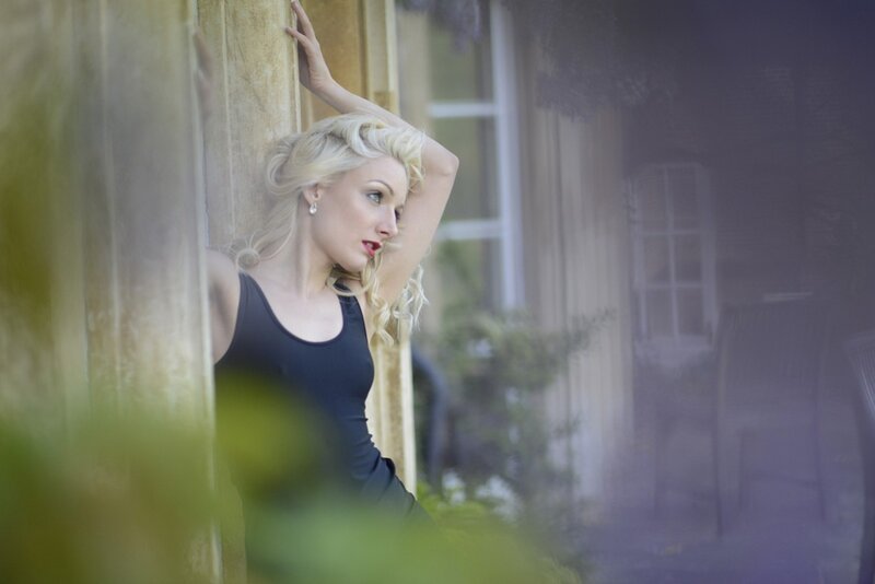 woman in black top leaning on pillar