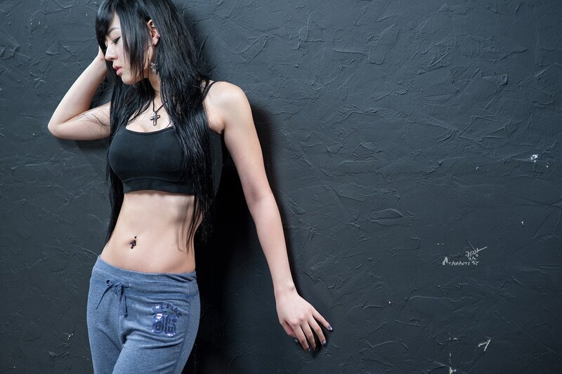woman in black top leaning on wall