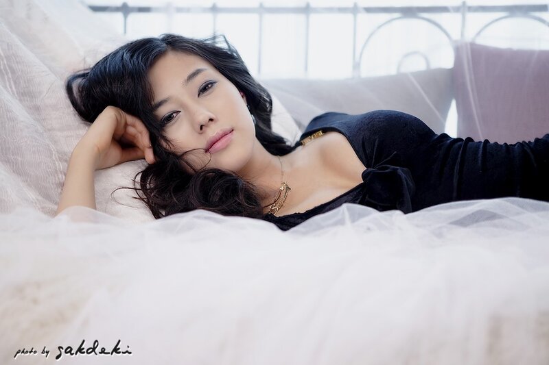 woman in black top lying on bed