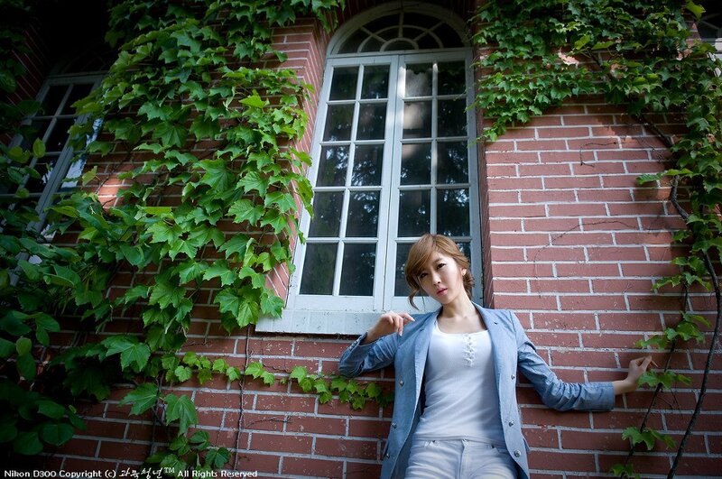 woman in blazer against brick wall