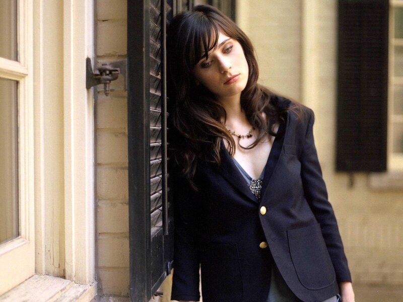 woman in blazer leaning against wall