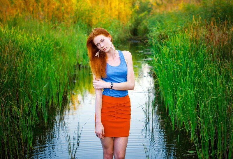 Woman in blue and orange by a stream