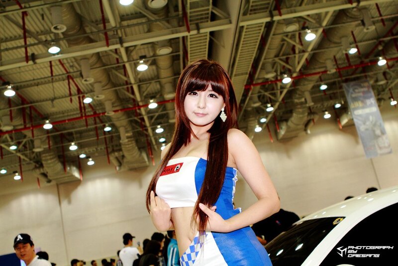 Woman in blue and white dress at auto show