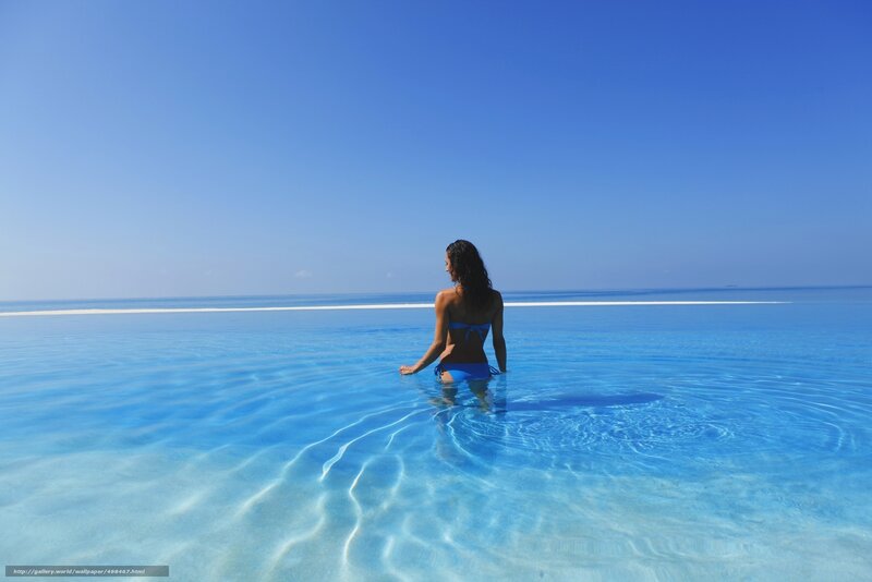 Woman in blue bikini at infinity pool