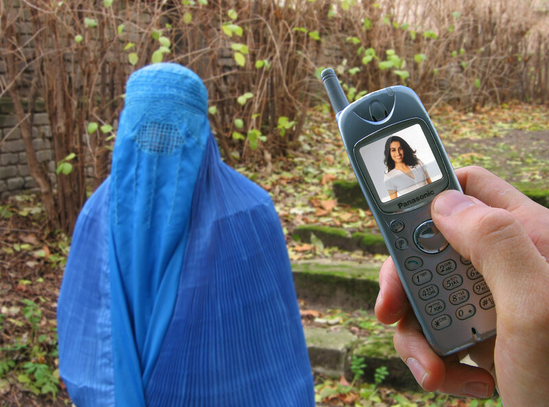 woman in blue burqa with phone