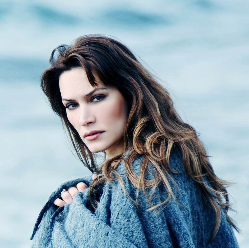 woman in blue coat by water