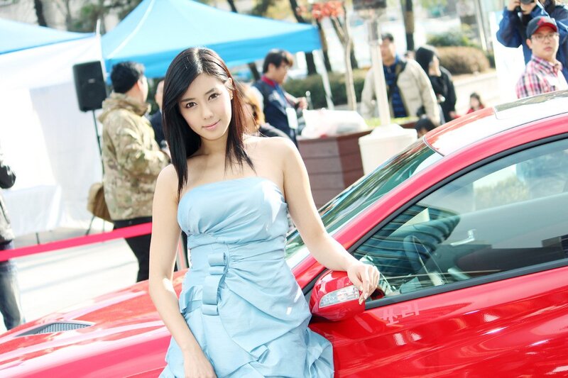 woman in blue dress at car event